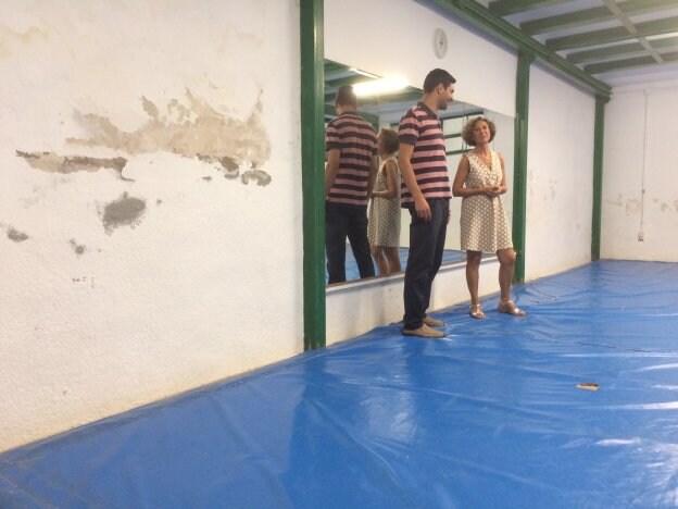 El alcalde y la directora muestran las humedades de una de las aulas ubicada en el sótano. 