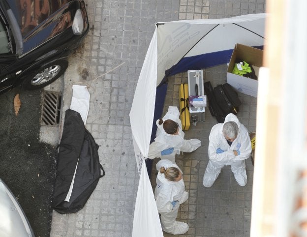 Policía Científica.Tres agentes de la Policía Científica junto al edificio donde murió el subinspector. 