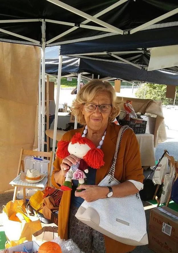 Carmena, con 'La Manuelita', el domingo en el puesto de Zapatelas en una feria solidaria. 