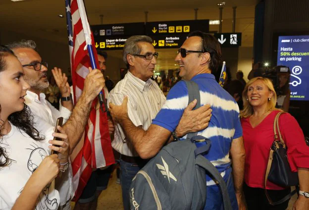 El ingeniero valenciano llega al aeropuerto de Manises, ayer, entre sus familiares, que enarbolan una bandera norteamericana. 