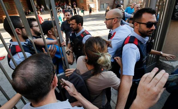 Varias personas tratan de acceder a un colegio electoral en Barcelona.