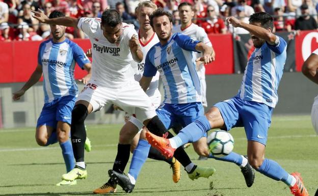 El sevillista Mercado disputa un balón con Recio. 