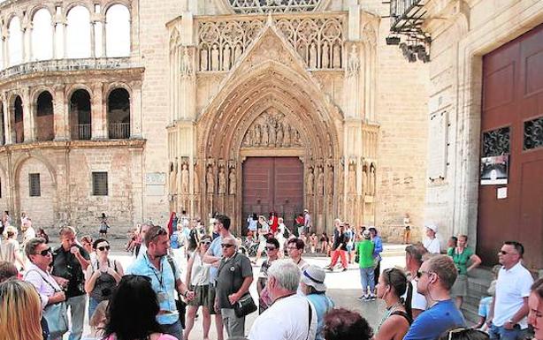 Un grupo de turistas con un guía en la plaza de la Virgen. 