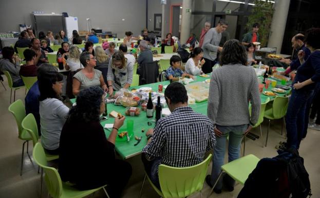 Varias personas cenan en un colegio ocupado de Vic (Barcelona).
