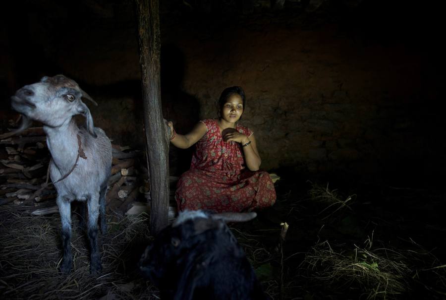 Laxmi Tamatta, de 20 años, descansa en el establo durante su menstruación en el distrito de Acham en Nepal.