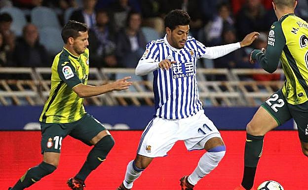 Carlos Vela, luchando un balón con Pablo Piatti.