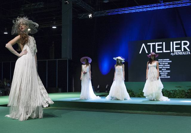 La vicepresidenta del Consell, Mónica Oltra, ha visitado la feria Fiesta y Boda y se ha probado una pieza de indumentaria valenciana en un expositor.