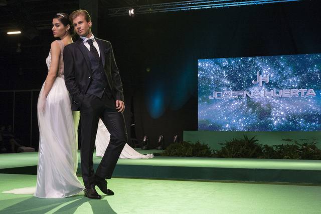 La vicepresidenta del Consell, Mónica Oltra, ha visitado la feria Fiesta y Boda y se ha probado una pieza de indumentaria valenciana en un expositor.