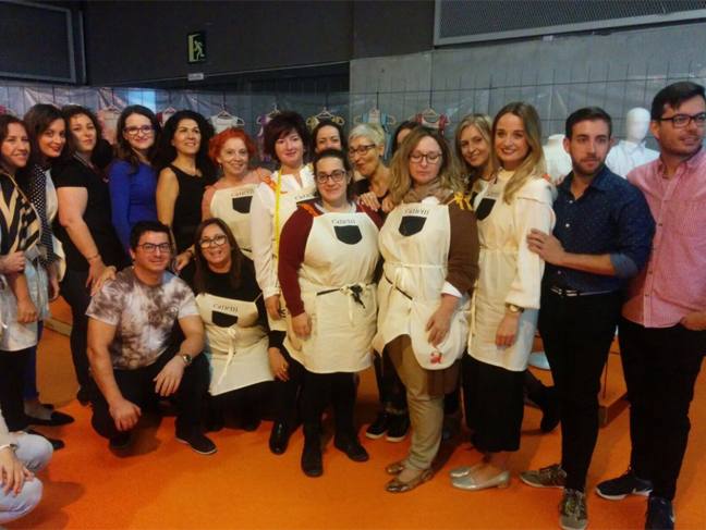La vicepresidenta del Consell, Mónica Oltra, ha visitado la feria Fiesta y Boda y se ha probado una pieza de indumentaria valenciana en un expositor.