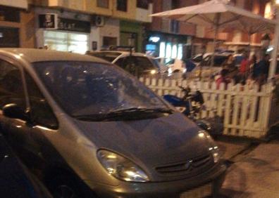 Imagen secundaria 1 - En la imagen de arriba, vivienda en la que han ocurrido los hechos. Abajo, a la izquierda, vehículo en el que ha caído el hombre tras lanzarse por la ventana. A la derecha, el cordón policial.