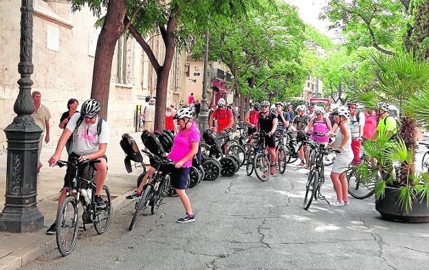 Un grupo de turistas se prepara para una visita guiada en bici por el centro de Valencia. 
