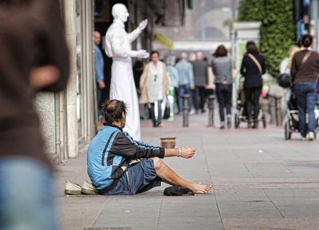 Una persona pide limosna en una calle de Alicante. 