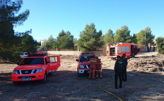 Bomberos y guardias civiles en la zona del incendio de Riba-roja.