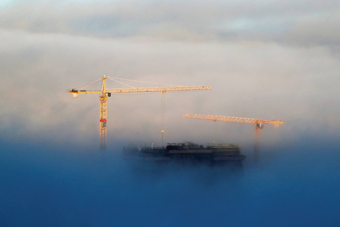 Dos grúas gigantes se entrevén en lo alto del nuevo Museo Munch mientras un manto de niebla cubre el centro de Oslo (Noruega) en este miércoles 15 de noviembre de 2017. 