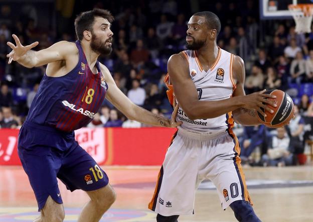 El alero del Valencia Basket Will Thomas (d) protege el balón ante Pierre Oriola, del FC Barcelona Lassa. 