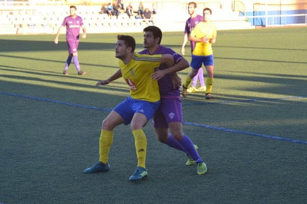 Madramany pugna con Poveda, del CD Dénia, en el partido disputado en el Diego Mena. 