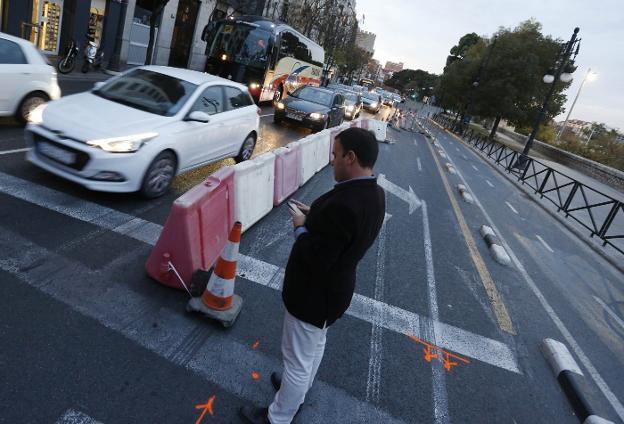 Un peatón esperando al disco en verde, junto a la zona cortada por las catas. 