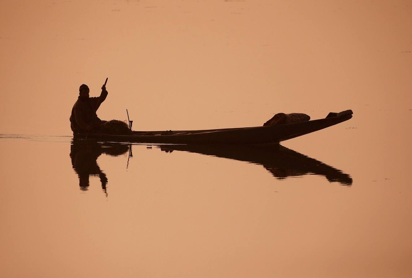 Un pescador, remando en su barca en el lago Dal en Srinagar, en Jammu y Cachemira (La India).
