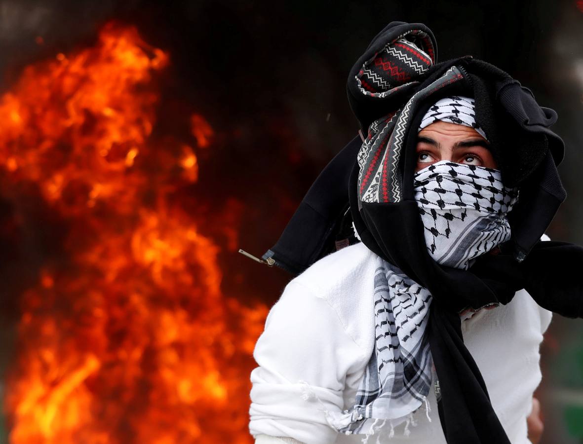 Un palestino observa en la ciudad cisjordana de Ramala la trayectoria de una piedra lanzada en las protestas contra el reconocimiento de Jerusalén como capital de Israel por parte de Donald Trump. 