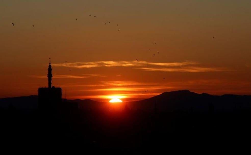 Puesta de sol con la silueta de la torre "El Miguelete" en primer plano durante el día de Navidad 