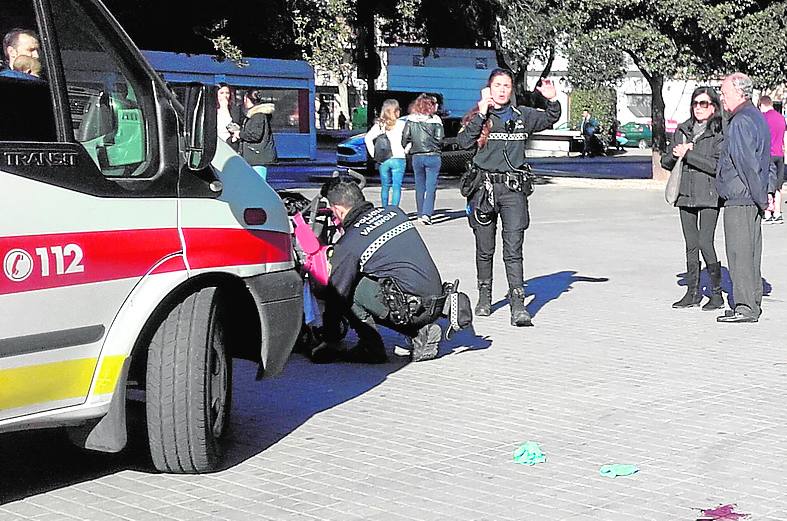 Atención inmediata. Un policía atiende al bebé de la joven herida en los aledaños de Mestalla.