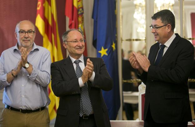 Alcaraz, conseller de Transparencia, y Morera, presidente de Les Corts, aplauden a Llinares (centro) en su nombramiento. 