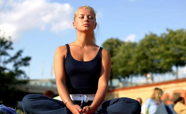 Mujer alemana realiza un ejercicio de meditación durante el Festival de Yoga .