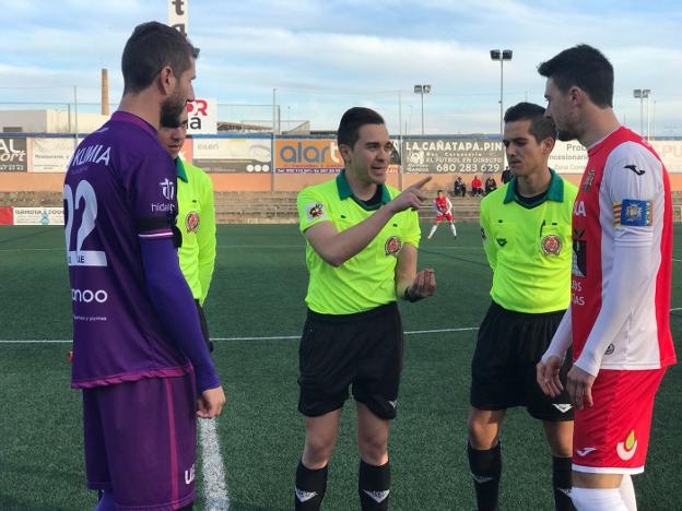 Raúl Muñoz, capitán de la UE Gandia, junto a los árbitros y al capitán del Benigànim antes del inicio del partido. 