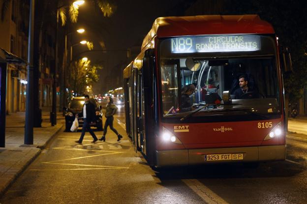 Usuarios bajan de un autobús nocturno cuando aún se podía aparcar en el carril bus por la noche. 