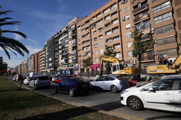 Decenas de coches esperan junto a una zona en obras en la avenida del Cid. 