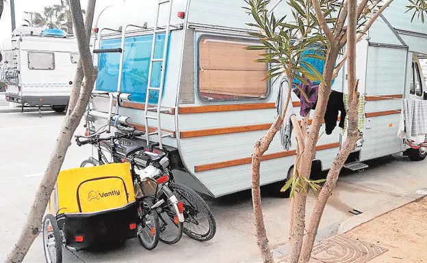 Caravanas y bicis. Una de las autocaravanas en la Malvarrosa, ayer.