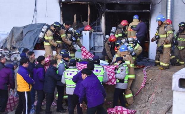 Miembros del equipo de rescate trasladan a las víctimas.