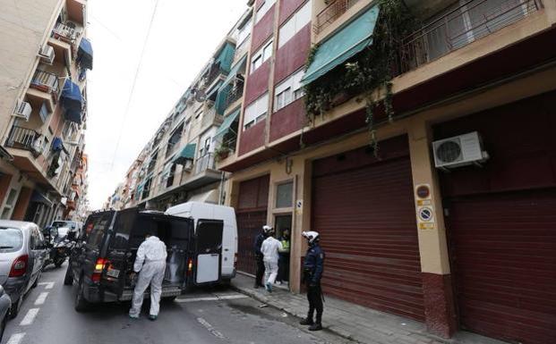 Personal del retén fúnebre y policías, junto al edificio escenario del asesinato.