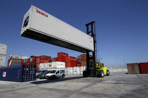 Un vehículo portuario cargando contenedores en Valencia. 
