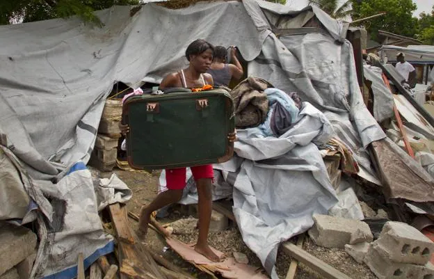 Desvalida. Una mujer acarrea una maleta entre los escombros, tras ser desalojada de un campo para desplazados. 