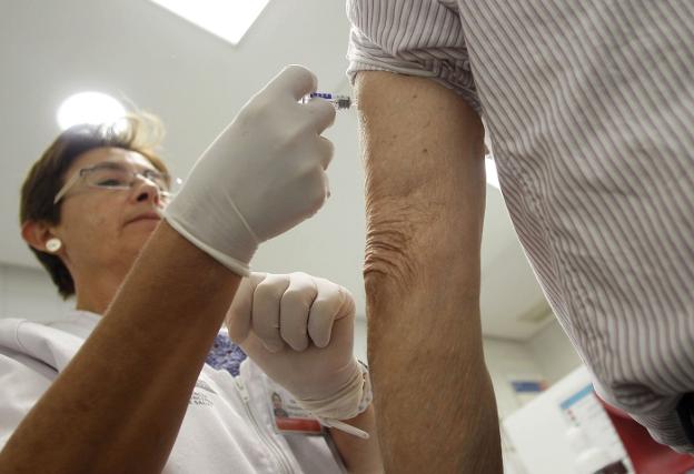 Una sanitaria aplica la vacuna de la gripe en un hospital valenciano. 