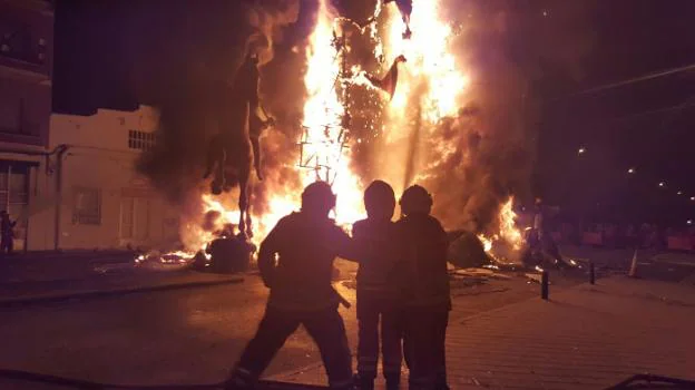 Tres bomberos trabajan durante una cremà en Silla. 