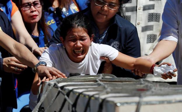 Jessica Demafelis llora la muerte de su hermana Joanna al recoger hoy sus restos mortales en el aeropuerto de Manila.