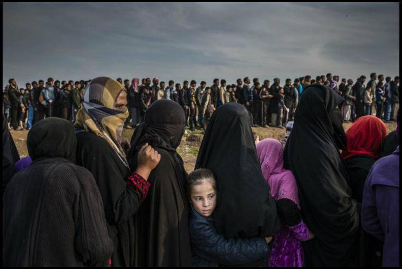 Otra imagen del fotógrafo Ivor Prickett para "The New York Times" acerca de la liberación de Mosul del Estado Islámico por parte de las fuerzas iraquíes. En la imagen se observa una larga cola de civiles que quedaron atrapados en la ciudad y que esperan su turno para el suministro de medicamentos, ya que habían sufrido escasez de alimentos y agua.