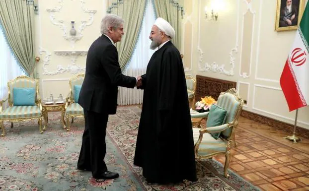 El presidente iraní, Hasan Rohaní (d), da la bienvenida al ministro español de Exteriores, Alfonso Dastis.