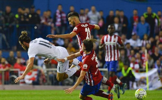 Yannick Carrasco lucha con Gareth Bale en un derbi madrileño. 