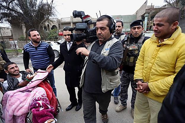 Un yihadista esposado llora al ser confrontado con sus víctimas ante las cámaras. Con traje, el presentador Ahmed Hasan. 