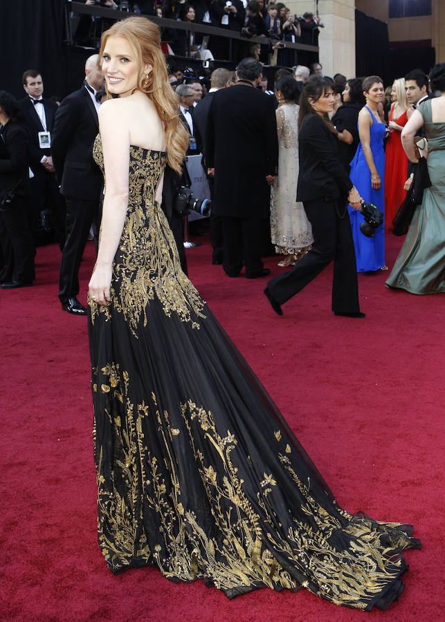 LOS MEJORES VESTIDOS | El vestido negro con escote corazón y bordados dorados de Alexander McQueen elevaron a Jessica Chastein al podio de las mejores vestidas de los Oscar 2012. 