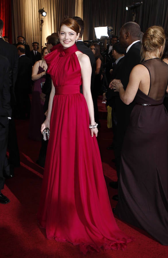 LOS MEJORES VESTIDOS | Emma Stone apostó en los Oscar de 2012 por este espectacular y vaporoso vestido con escote halter y lazo al cuelo de Giambattista Valli. El clutch y las joyas son de Louis Vuitton.