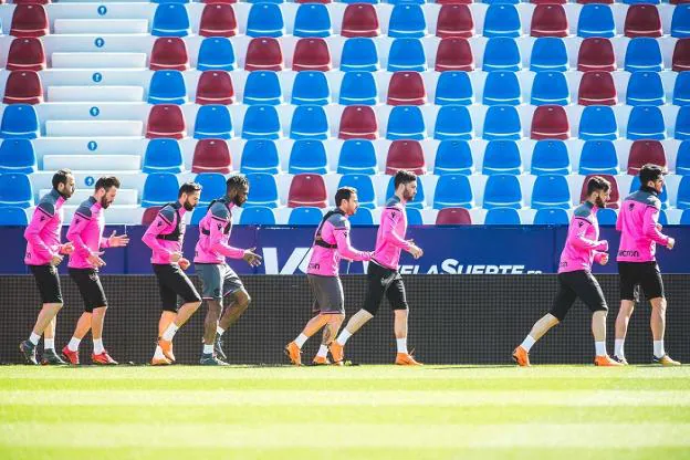 Los jugadores del Levante realizan ejercicios de calentamiento para la sesión previa al partido de esta mañana.