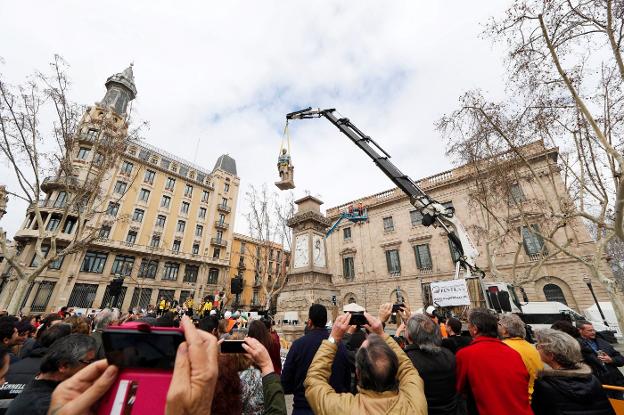 A la izquierda, la grúa retira la estatua. Abajo, los operarios amarran a Antonio López. 
