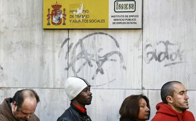 Varias personas hacen cola ante la oficina del INEM en Madrid. 
