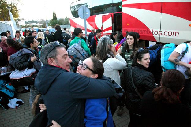 Una de las alumnas que realizó el viaje a Sierra Nevada recibe un abrazo de su padre tras bajarse del autobús. 