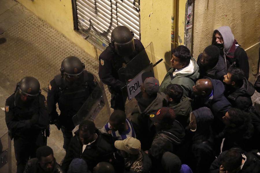 Un grupo de más de medio centenar de personas han quemado contenedores y causado desperfectos en el mobiliario urbano en el madrileño barrio de Lavapiés tras la muerte este jueves de un mantero de 35 años y origen subsahariano a causa de una parada cardiorrespiratoria.