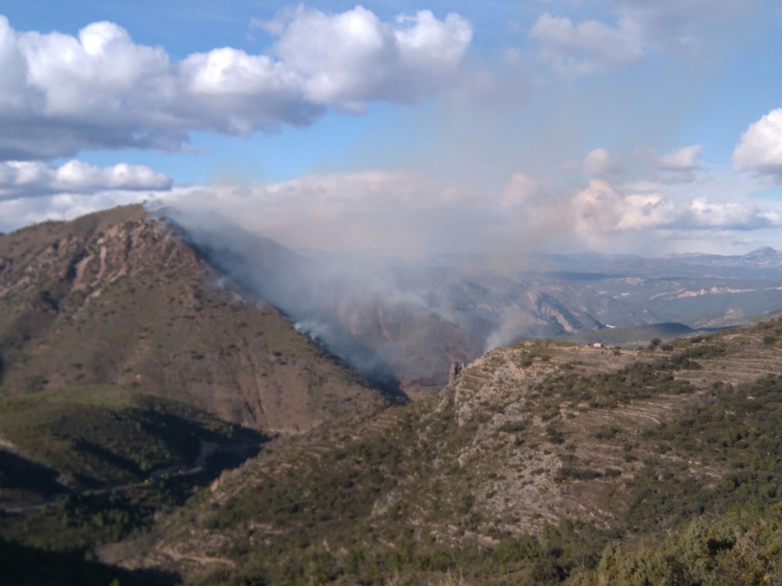 Efectivos aéreos y terrestres de bomberos trabajan en la extinción de un incendio en Montán